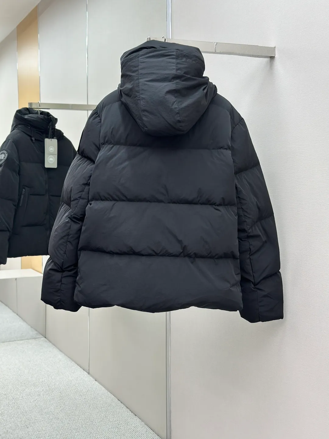 P1010 Canada Goose Black Label Badge Hooded Down Jacket (khaki) The high-quality filling is made of 90 national standard high-quality white duck down, selected high-loft velvet, weighing 240g, light and warm, with excellent temperature locking performance and good resilience. The fabric is woven with 400T high-count yarn. After special water-repellent treatment, the surface forms a lotus leaf effect - raindrops will slide down like beads, and snow particles will fall off when touched. The tear resistance reaches 200N (approximately 20kg load-bearing), the light gray matte texture breaks the stereotype of "outdoor clothing = hardcore", and the soft luster presents a high-end matte effect under urban neon lights, seamlessly switching scenes from ski resorts to CBD office buildings. The ribbon is woven with polyester as the base, and the brand letters are decorated on the ribbon through high-precision computer embroidery. The edges of the pattern are clear, the stitches are fine and even, and multiple layers of embroidery thread are stacked to enhance the three-dimensional effect. Precision thread reinforcement prevents linting and ensures the fluffy and resilient elasticity lasts as new. The embedded cuffs are three-dimensionally woven to form a "wavy" elastic structure, which forms natural folds when fitting the wrist, increasing the contact area with the skin, thus improving the windproof effect. At the same time, micro-velvet treatment is added to the inside of the cuffs, which feels like a second layer of skin and avoids friction on the skin from metal zippers or hard fabrics. Size:S-M-L-XL